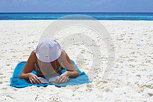Young women is reading the book on the beach