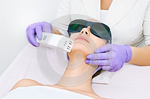 Young woman receiving epilation laser treatment photo