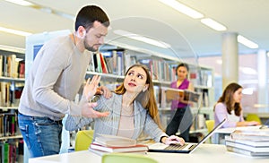 Woman rejects man help while preparing for exams in public library photo