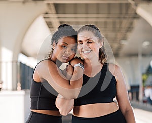 Young women relaxing after intense workout hugging each other