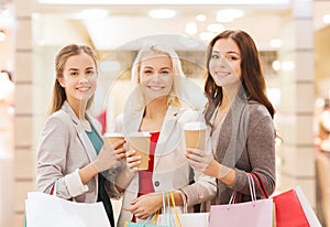 Young women with shopping bags and coffee in mall