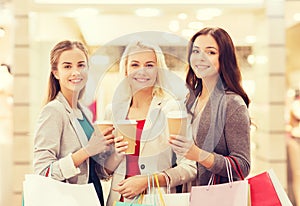 Young women with shopping bags and coffee in mall