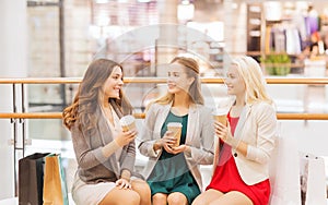 Young women with shopping bags and coffee in mall