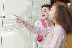 Young woman showing something in the shop window to her husband