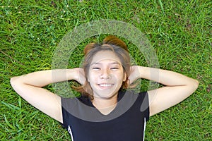 Young women sleep on grassland with her face smile