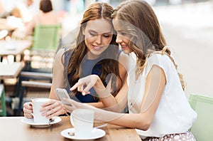 Young women with smartphone and coffee at cafe