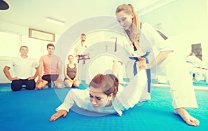 Young women in sparring work out painful techniques