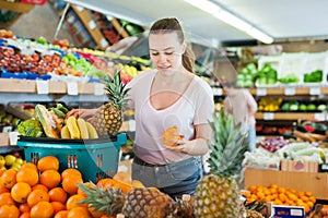 Young woman standing with full grocery cart during shopping