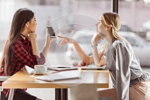 Young women talking while having business lunch meeting in cafe