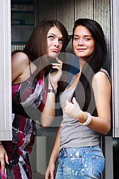 Young women talking on payphone