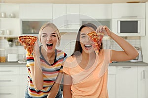Young women with tasty pizza laughing