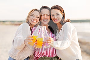 Young women toasting non alcoholic drinks on beach