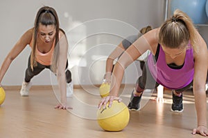 Young women training with medicine balls in fitness class