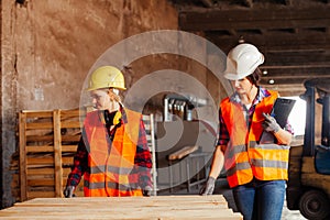 The young women in uniform working in a factory