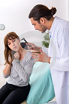 Young woman visting young male doctor otorhinolaryngologist photo