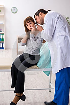 Young woman visting young male doctor otorhinolaryngologist photo