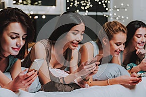 Young women watching at cellphones in room