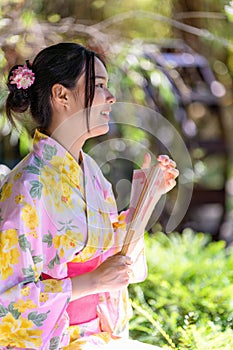 Young women wearing traditional Japanese kimono or yukata is happy and cheerful in the park