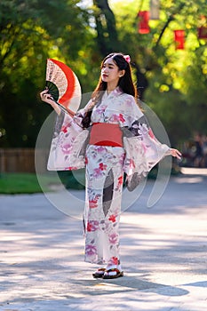 Young women wearing traditional Japanese kimono or yukata is happy and cheerful in the park