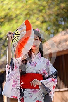 Young women wearing traditional Japanese kimono or yukata is happy and cheerful in the park