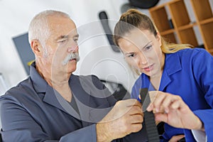 Young woman working at carpenter shop with teacher