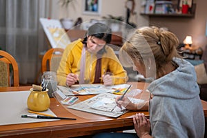 Young women working on watercolor painting of cityscape