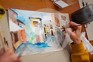 Young women working on watercolor painting of cityscape