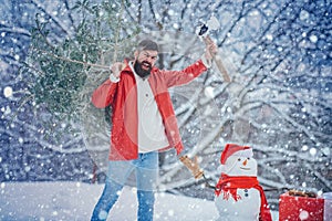 Young woodcutter winter portrait. Winter portrait of lumber in snow Garden cutting Christmas tree. Young lumberjack