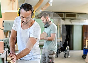 Young worker in a carpenter`s workshop using milling machine