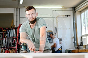 Young worker in a carpenters workshop photo