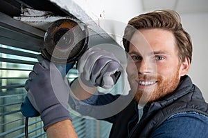 young worker grinding window smiling