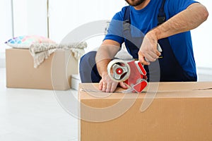 Young worker packing box in room, closeup