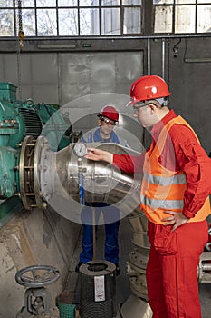 Young Worker in Personal Protective Equipment Checking Pressure Gauge Instrument