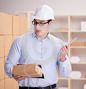 Young worker in the postal office dealing with parcels