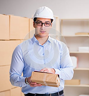 Young worker in the postal office dealing with parcels