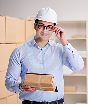 Young worker in the postal office dealing with parcels