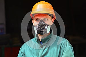 Young worker in protective helmet and respirator