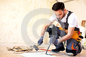 Young worker removing old flooring