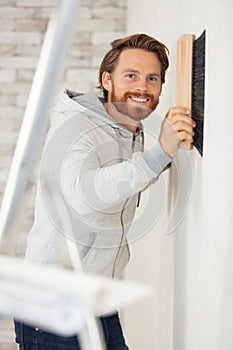 young worker renewing apartment on wall background