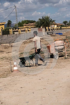 Young worker moving cement with a forklift photo