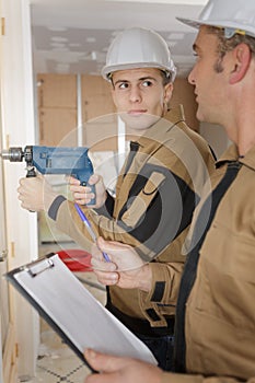 Young worker using electric drill