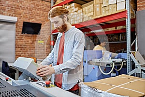 Young Worker Using Machines in Printshop