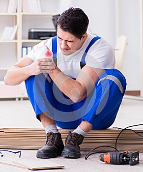 Young worker working on floor laminate tiles