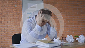 Young working man is very tired and overworked because of stressful and pressure business tasks siting at the table 4K