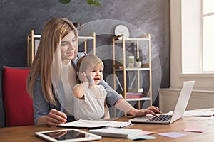 Young working mother spending time with baby