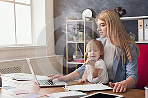 Young working mother spending time with baby
