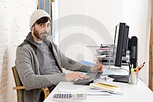 Young worried businessman in cool hipster beanie look looking desperate having problem working in stress