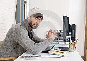 Young worried businessman in cool hipster beanie look looking desperate having problem working in stress