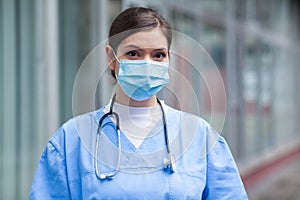 Young worried stressed anxious female EMS key worker doctor portrait outside hospital