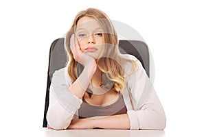 Young worried woman sitting at the desk